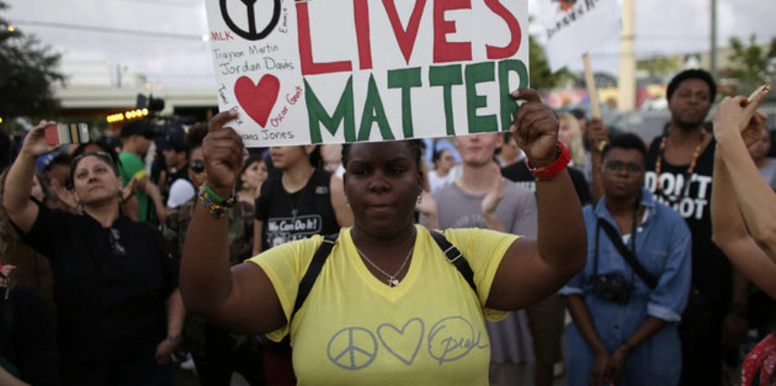 Desiree Griffiths, 31, of Miami, holds up a sign saying 